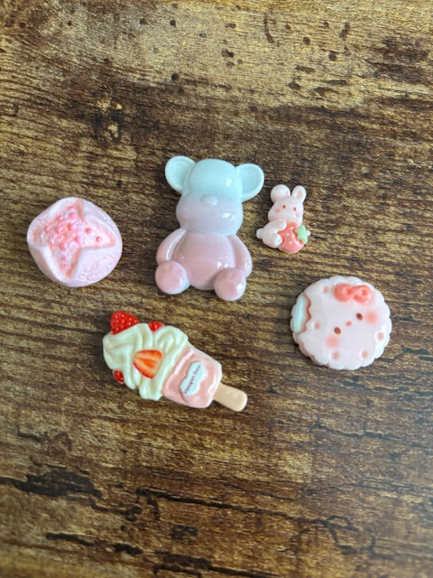 Set of colorful resin charms on a wooden surface