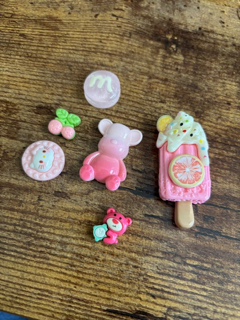 Set of colorful resin charms on a wooden surface