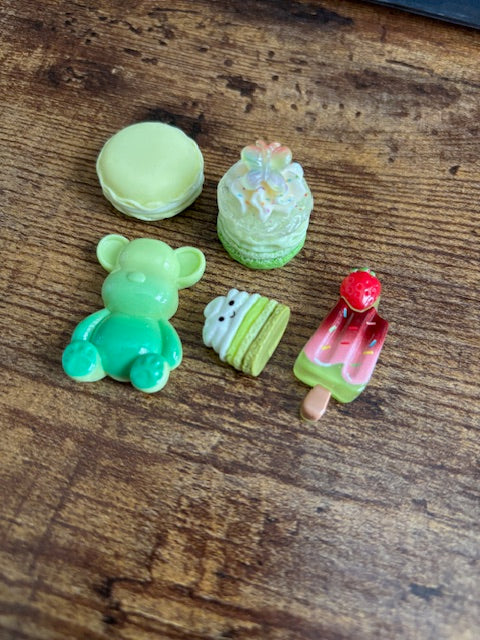 Set of colorful miniature ice cream, cake, and a bear on a wooden surface