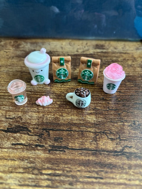 Starbucks-themed resin charms on a wooden surface