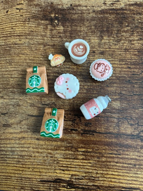 Set of miniature Starbucks-themed items on a wooden surface