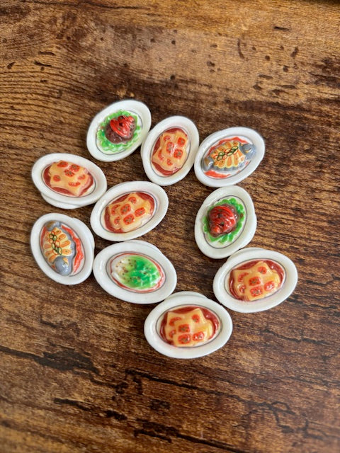 Set of miniature food items in white containers on a wooden surface