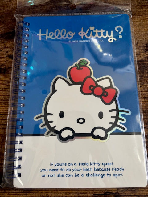 Hello Kitty notebook with a blue cover on a wooden surface