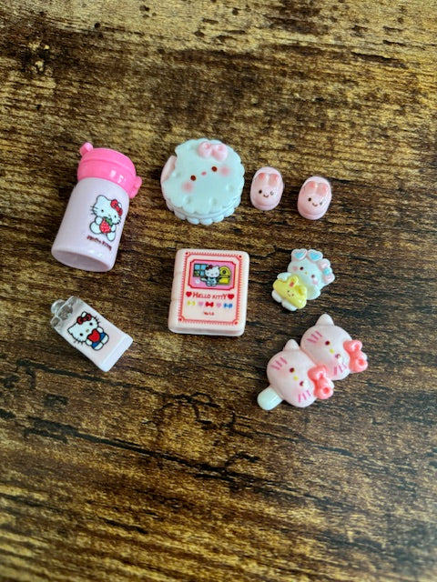 Collection of small Hello Kitty-themed items on a wooden surface