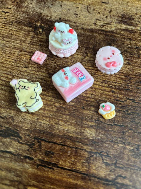 Small decorative items resembling candies or toys on a wooden surface