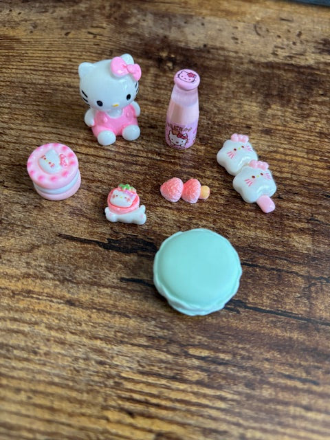 Set of small, colorful cat-shaped objects on a wooden surface