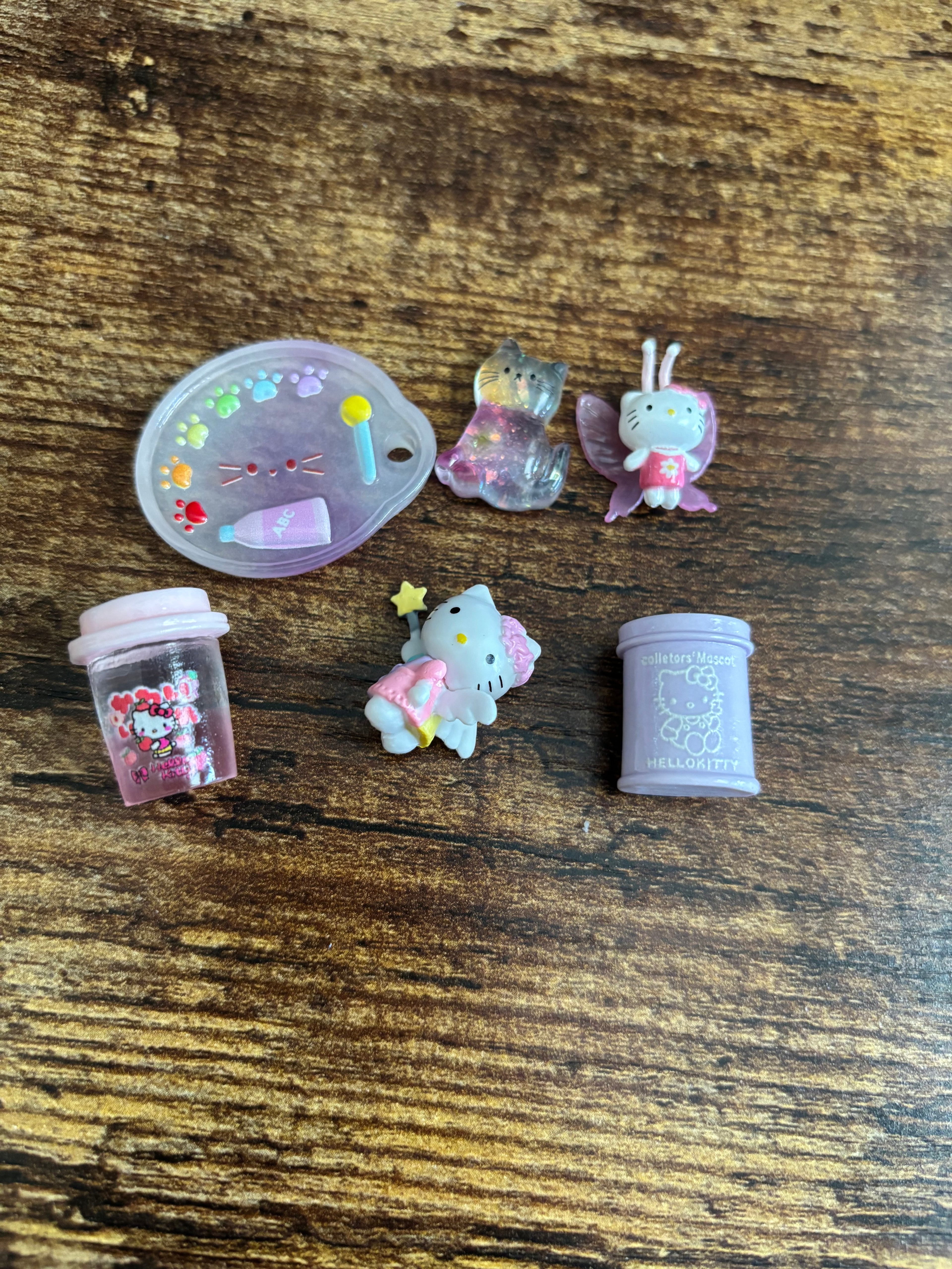 Small decorative items including a Hello Kitty figurine and a purple container on a wooden surface.