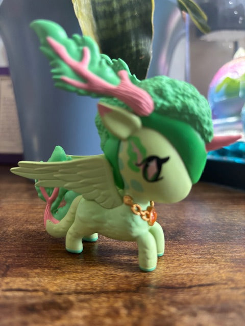 Green nature dragon figure on a wooden surface