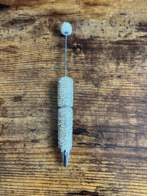 silver rhinestone pen on wooden surface
