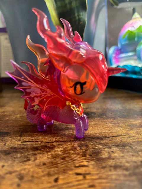 Colorful plastic dragon figurine on a wooden surface
