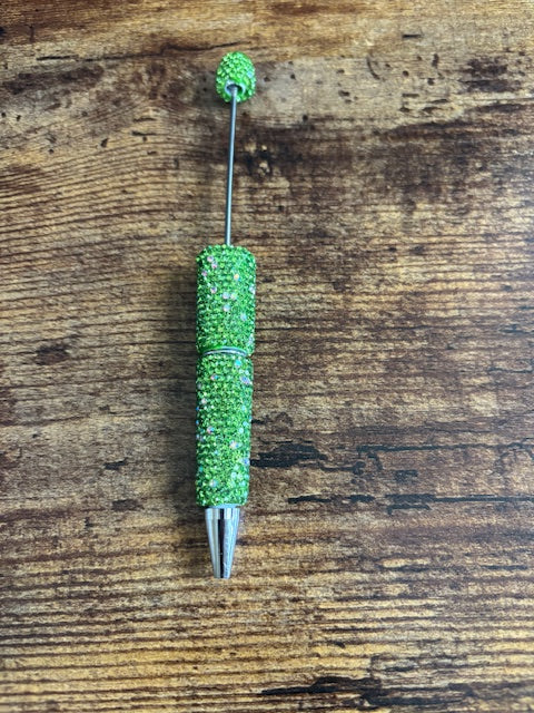 Green rhinestone pen on a wooden surface