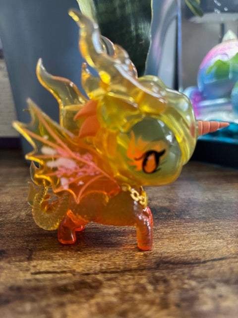 Colorful ember dragon figure against a wooden background