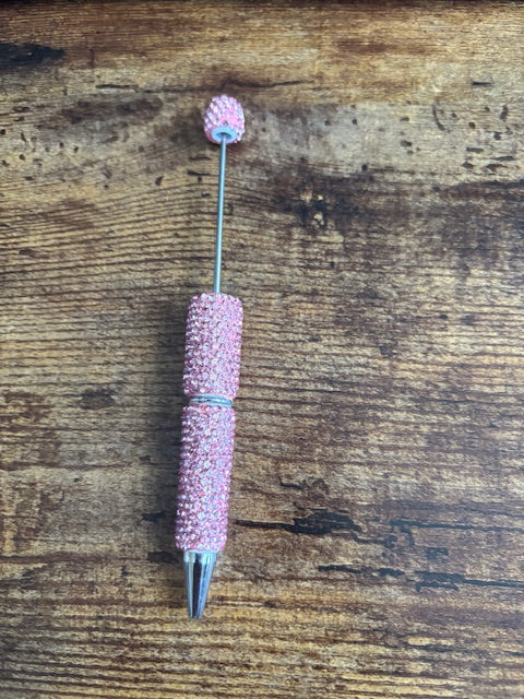 Pink rhinestone pen on a wooden surface